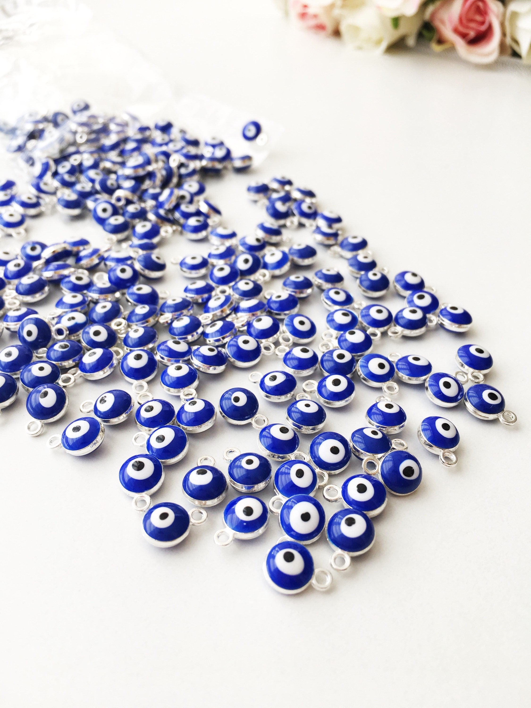 A collection of 10 blue evil eye charms made from brass, featuring a glossy enamel finish and a 2-sided design.