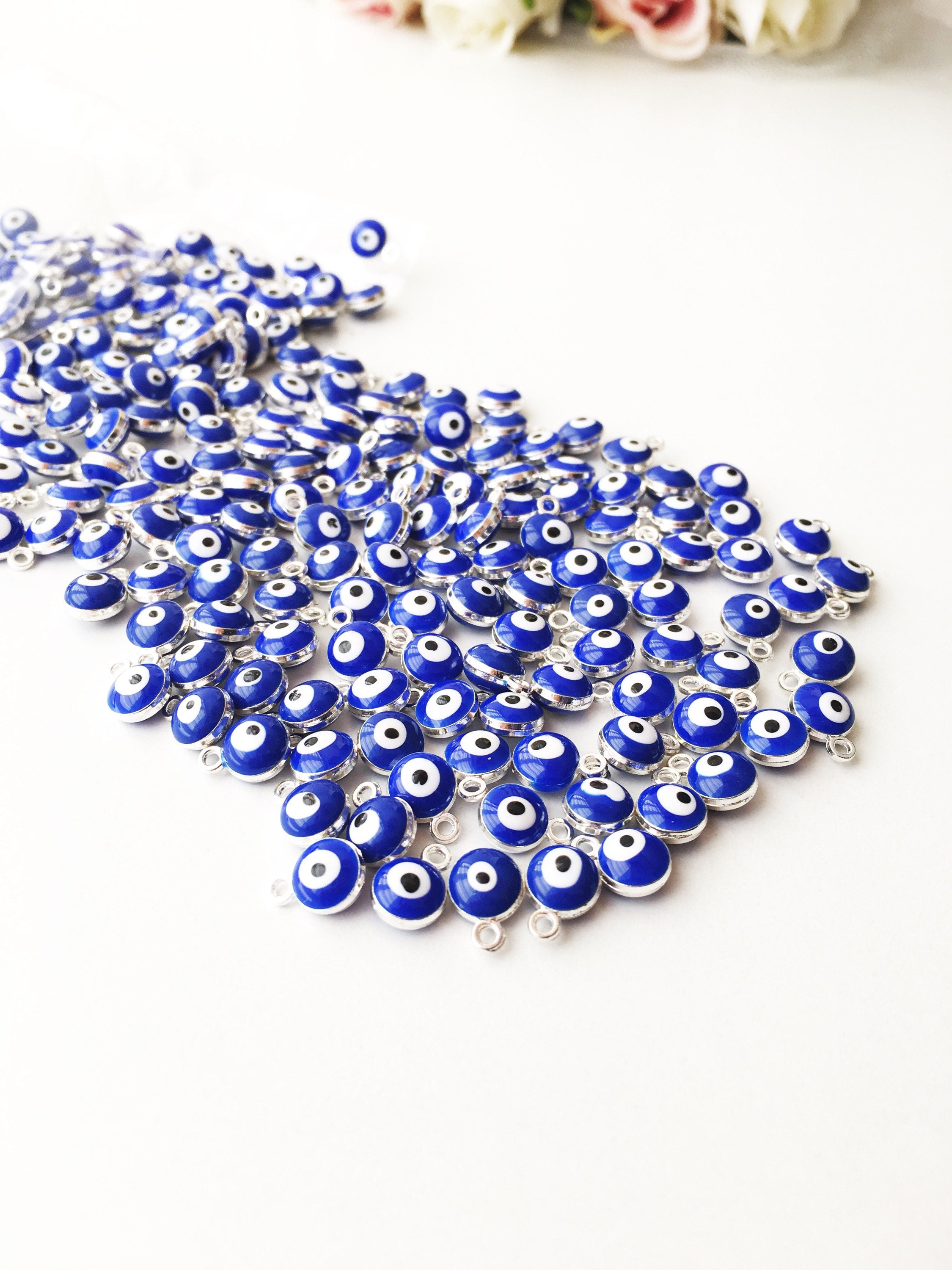 A collection of 10 blue evil eye charms made from brass, featuring a glossy enamel finish and a 2-sided design.