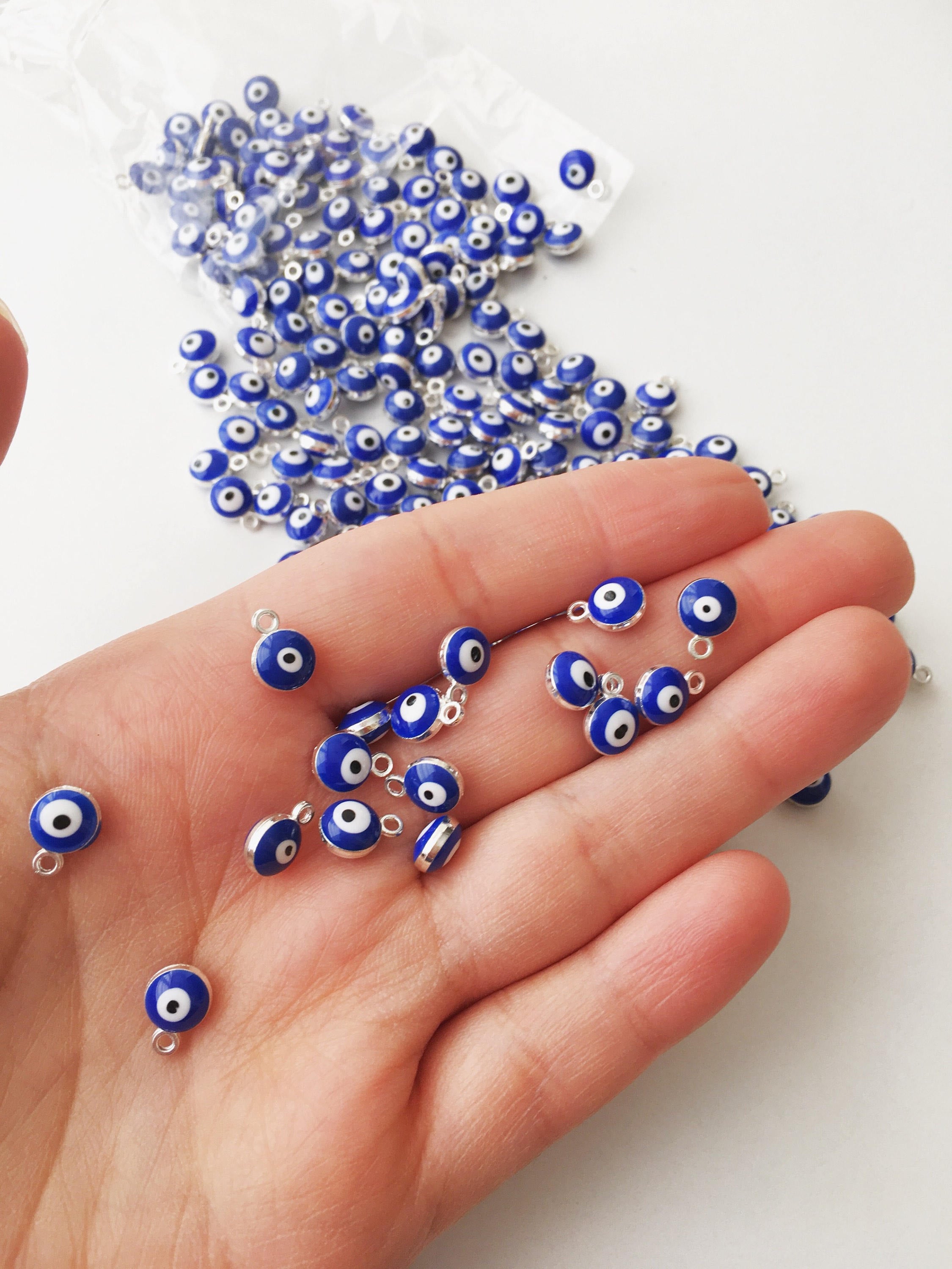 A collection of 10 blue evil eye charms made from brass, featuring a glossy enamel finish and a 2-sided design.