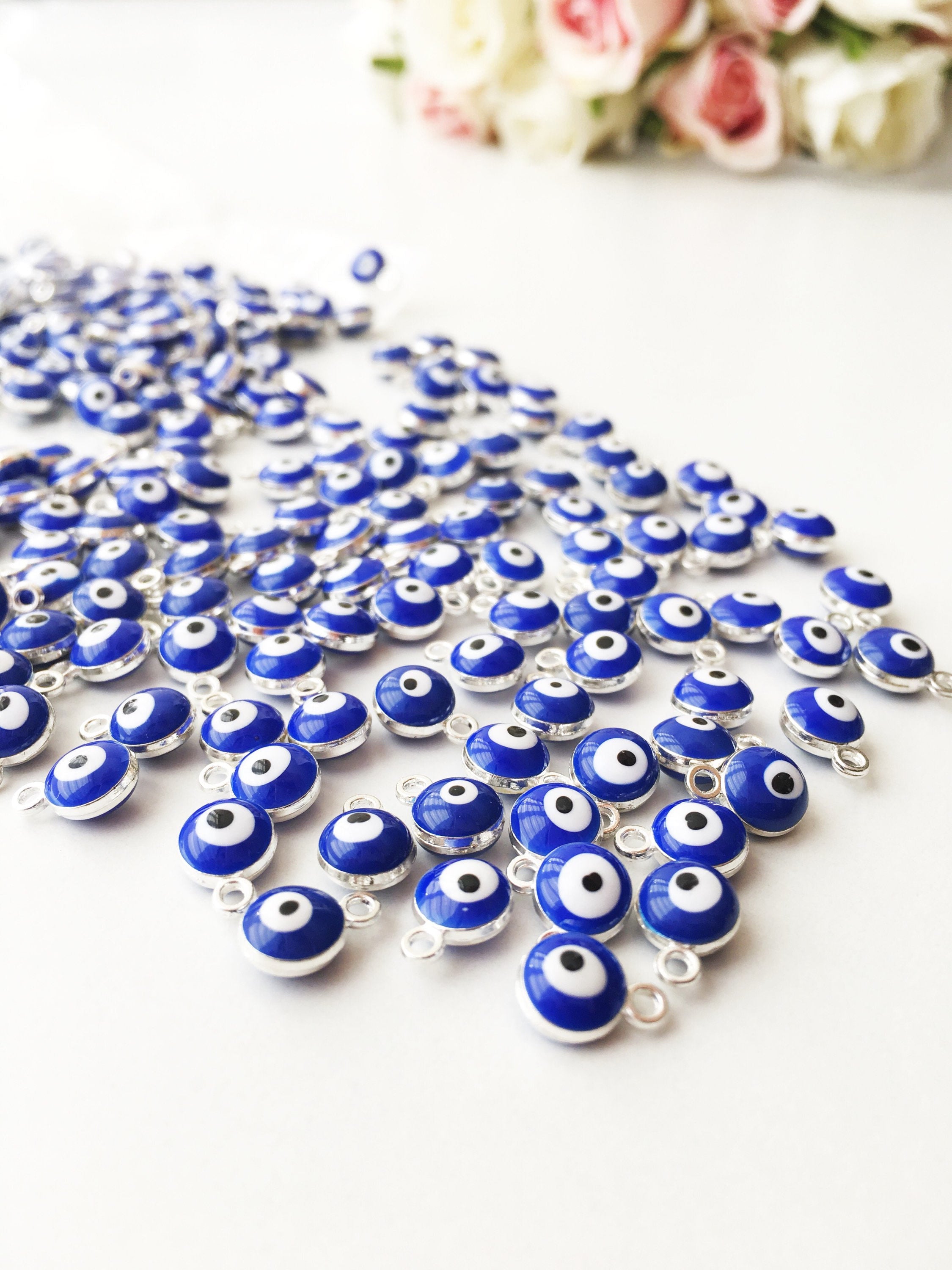 A collection of 10 blue evil eye charms made from brass, featuring a glossy enamel finish and a 2-sided design.