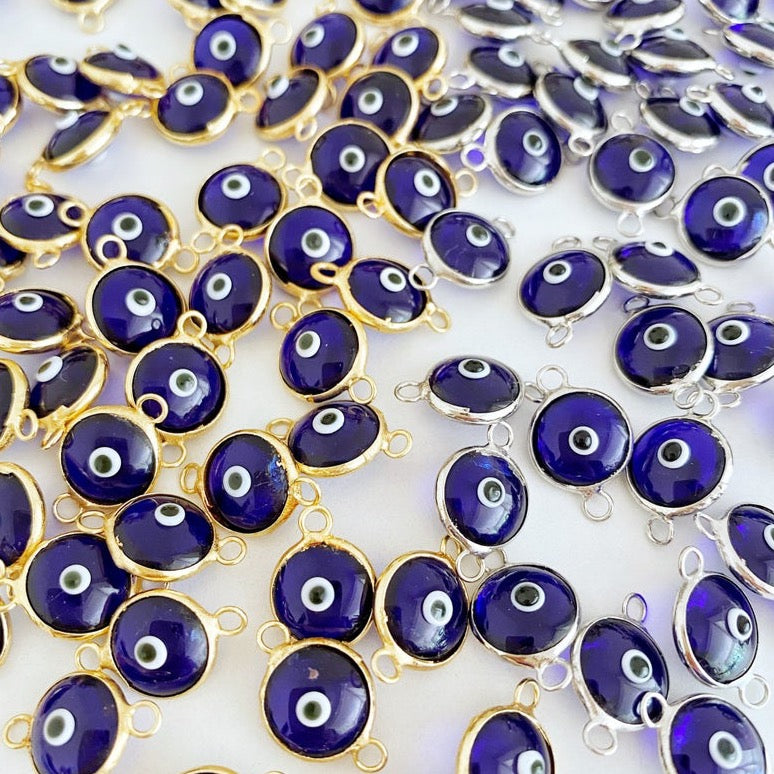 A collection of blue evil eye charms, handmade glass connectors featuring a traditional evil eye design, perfect for jewelry making.