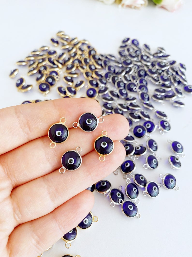 A collection of blue evil eye charms, handmade glass connectors featuring a traditional evil eye design, perfect for jewelry making.