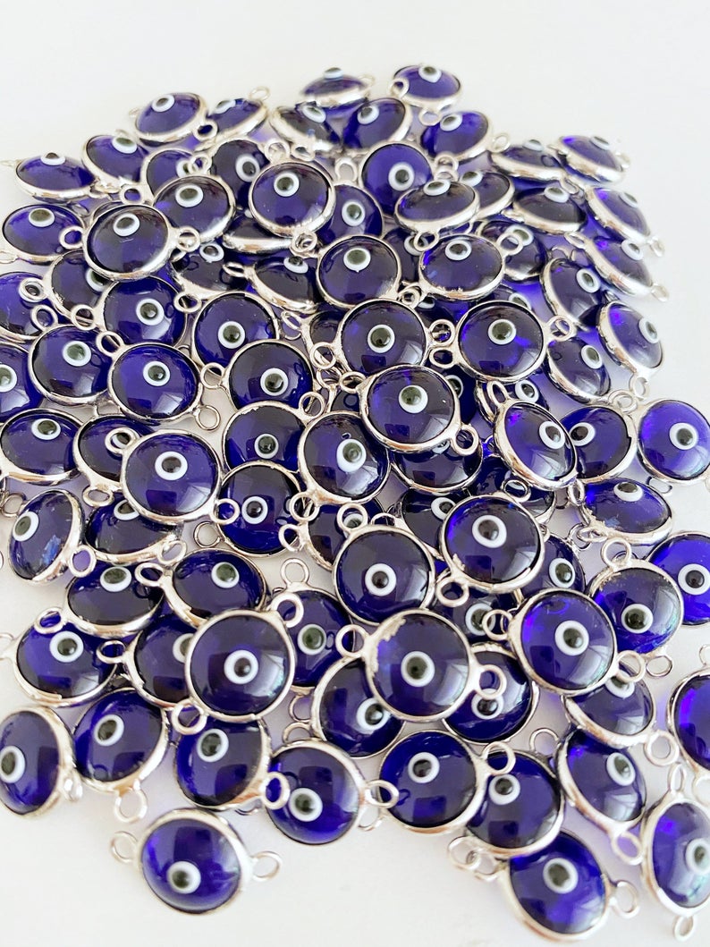 A collection of blue evil eye charms, handmade glass connectors featuring a traditional evil eye design, perfect for jewelry making.