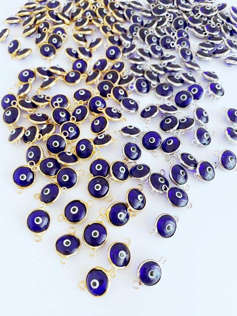 A collection of blue evil eye charms, handmade glass connectors featuring a traditional evil eye design, perfect for jewelry making.