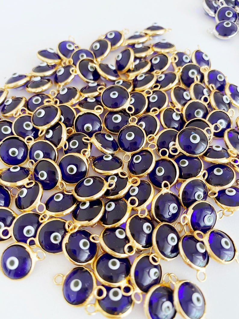 A collection of blue evil eye charms, handmade glass connectors featuring a traditional evil eye design, perfect for jewelry making.