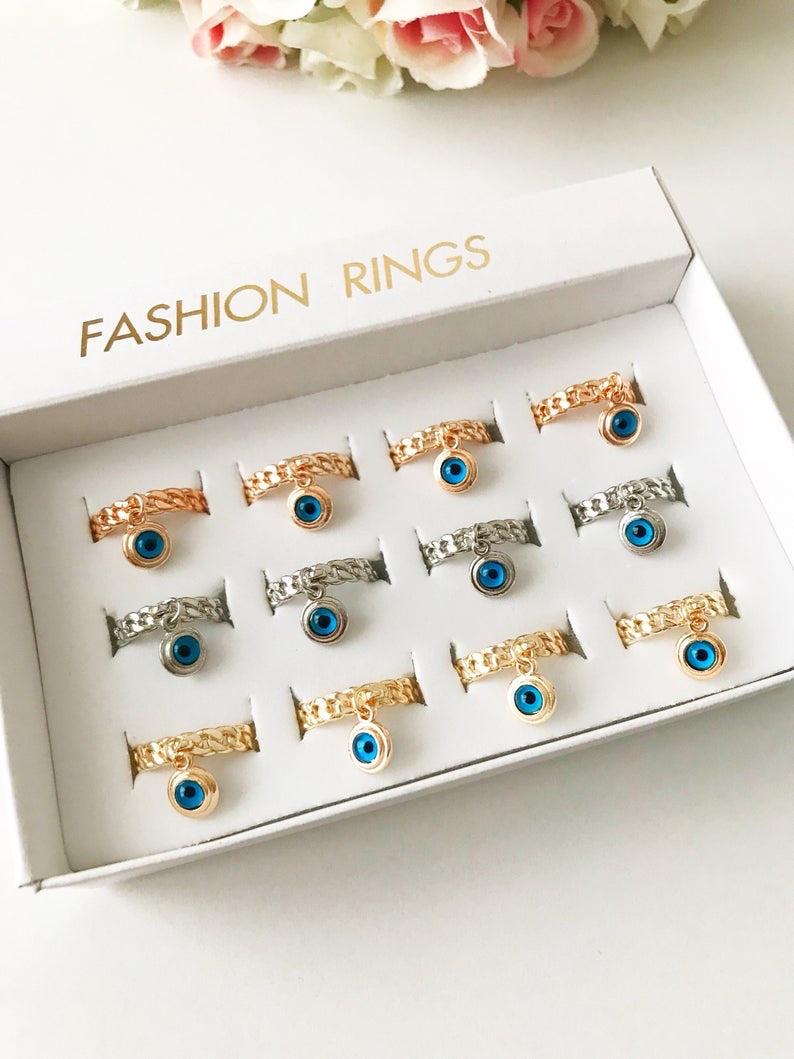 A stylish Blue Evil Eye Dangle Ring featuring a round blue evil eye bead, available in rose gold, silver, and gold finishes.