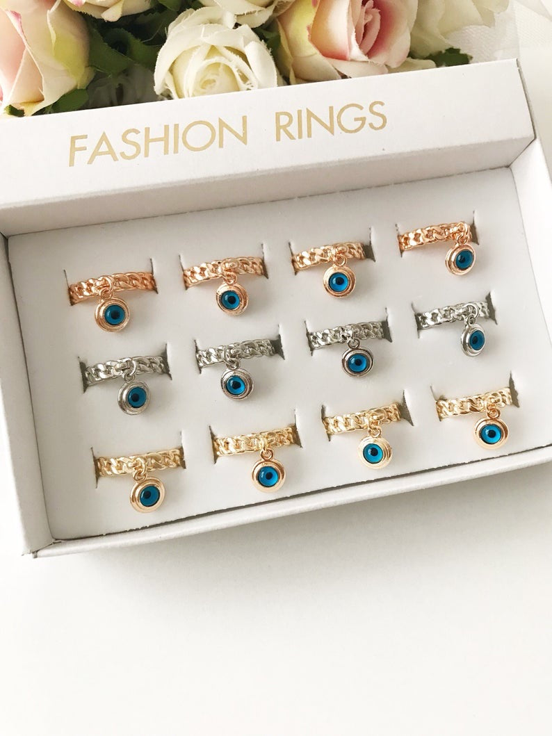 A stylish Blue Evil Eye Dangle Ring featuring a round blue evil eye bead, available in rose gold, silver, and gold finishes.