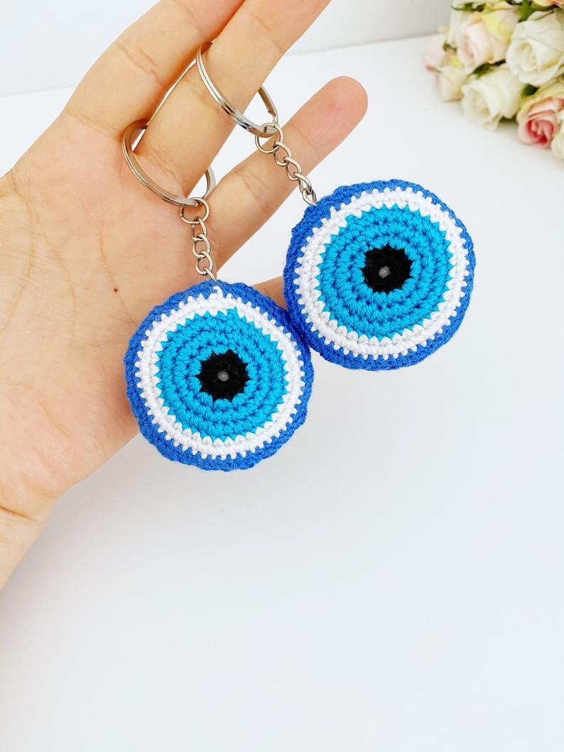 A beautifully handcrafted Blue Evil Eye Keychain made from cotton and silver, featuring a macrame design that symbolizes protection and good fortune.