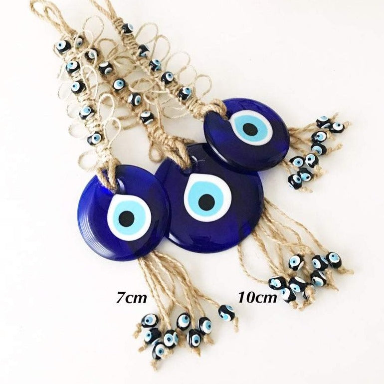 Handmade blue evil eye macrame wall hanging featuring a large evil eye bead and tiny blue beads, perfect for home decor.