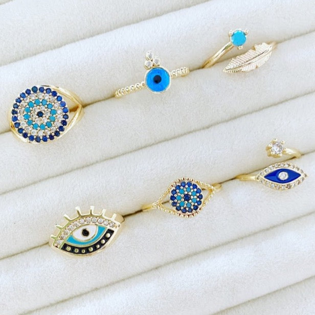 A beautiful set of adjustable blue evil eye rings with gold bands and zircon accents, showcasing six unique styles.