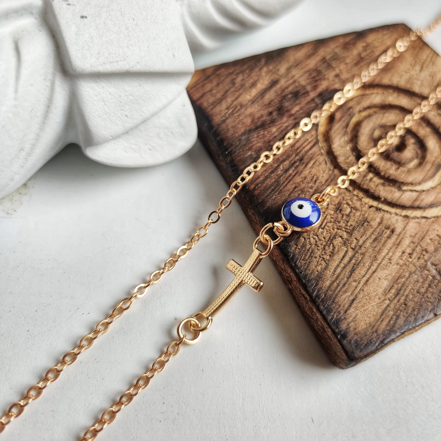 Blue Evil Eye Sideways Cross Necklace featuring a minimalist choker design with an evil eye bead and cross charm in gold and silver options.