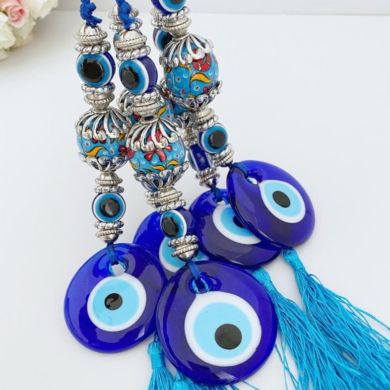 A beautiful handmade Blue Evil Eye Wall Hanging featuring a central evil eye bead and decorative tassel, perfect for home decor.