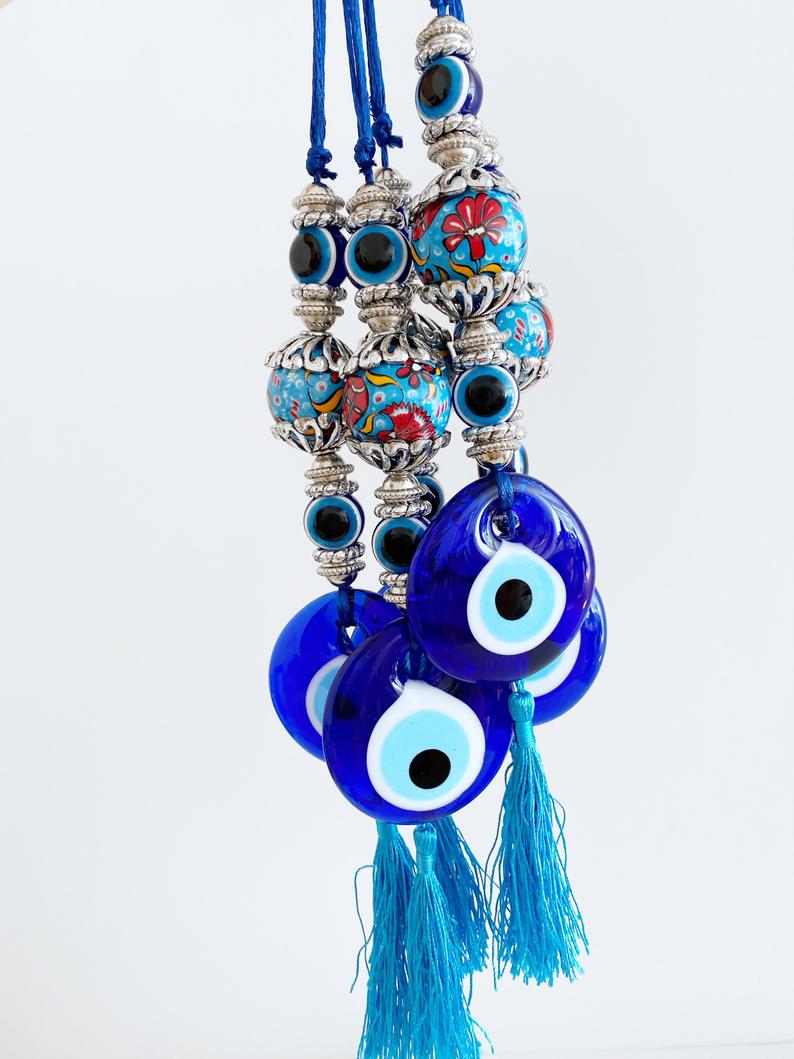 A beautiful handmade Blue Evil Eye Wall Hanging featuring a central evil eye bead and decorative tassel, perfect for home decor.