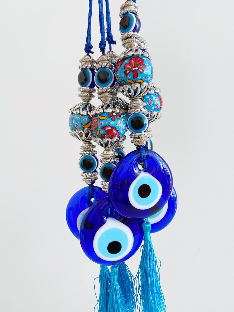 A beautiful handmade Blue Evil Eye Wall Hanging featuring a central evil eye bead and decorative tassel, perfect for home decor.