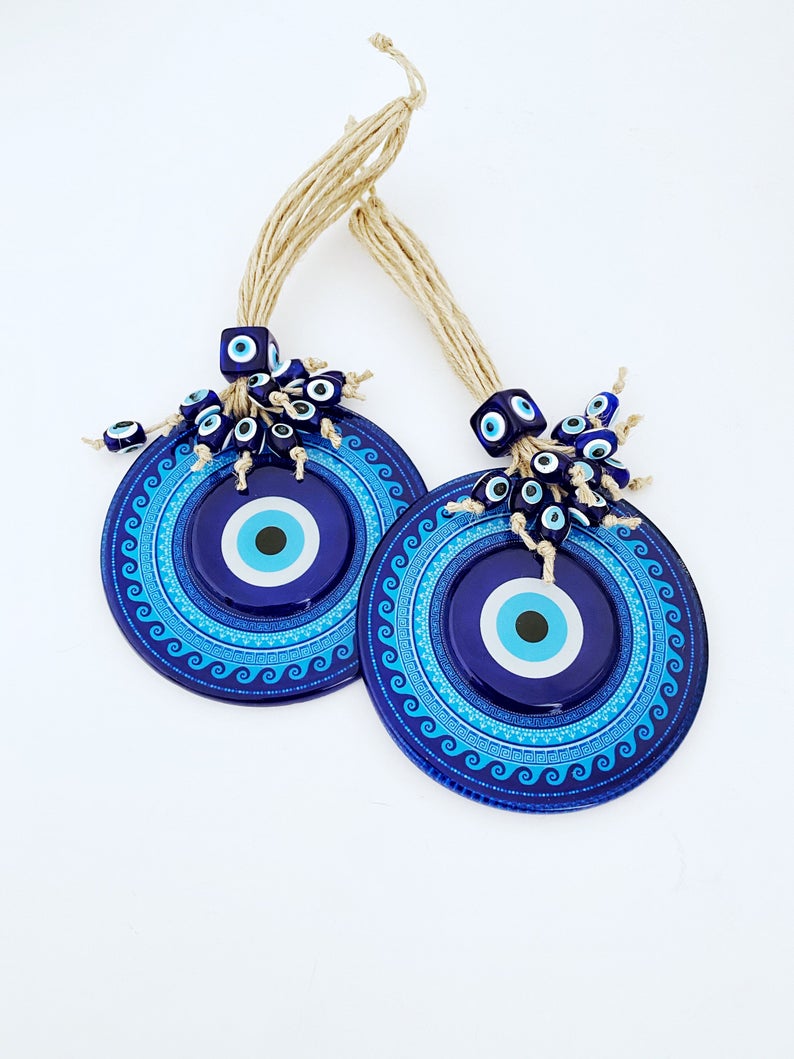 A beautifully handcrafted Blue Evil Eye Wall Hanging featuring a macrame design and a fused glass evil eye bead, perfect for home decor.