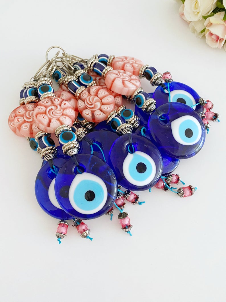 Handmade Blue Evil Eye Wall Hanging with pink beads, featuring a protective charm for home decoration.