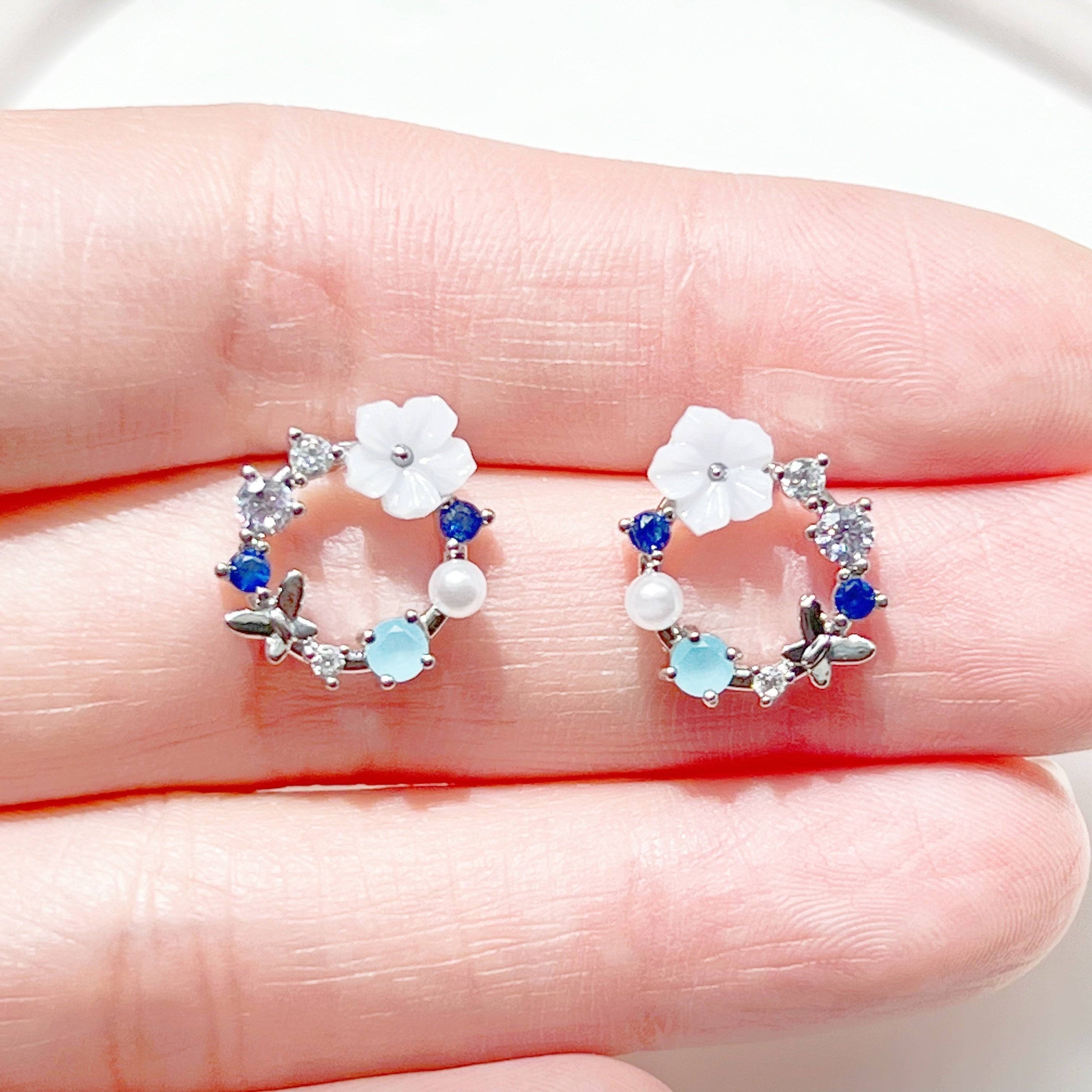 A pair of elegant blue flower wreath earrings featuring blue zircon and pearl, set in gold-plated bronze with sterling silver ear studs.