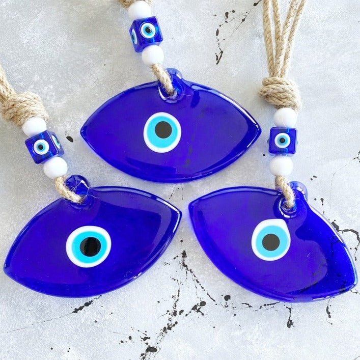 Handmade Blue Greek Evil Eye Wall Hanging featuring a large eye design and macrame details, perfect for home decor.