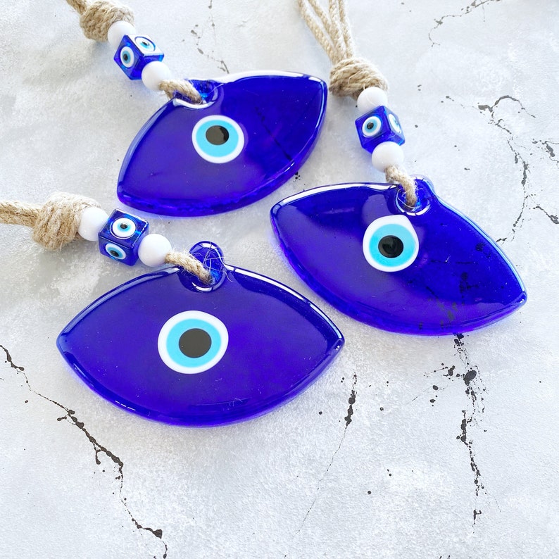 Handmade Blue Greek Evil Eye Wall Hanging featuring a large eye design and macrame details, perfect for home decor.