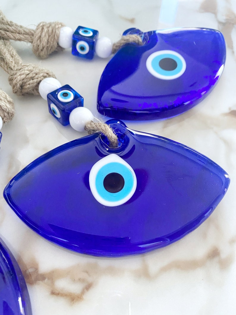 Handmade Blue Greek Evil Eye Wall Hanging featuring a large eye design and macrame details, perfect for home decor.