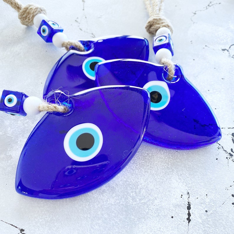 Handmade Blue Greek Evil Eye Wall Hanging featuring a large eye design and macrame details, perfect for home decor.