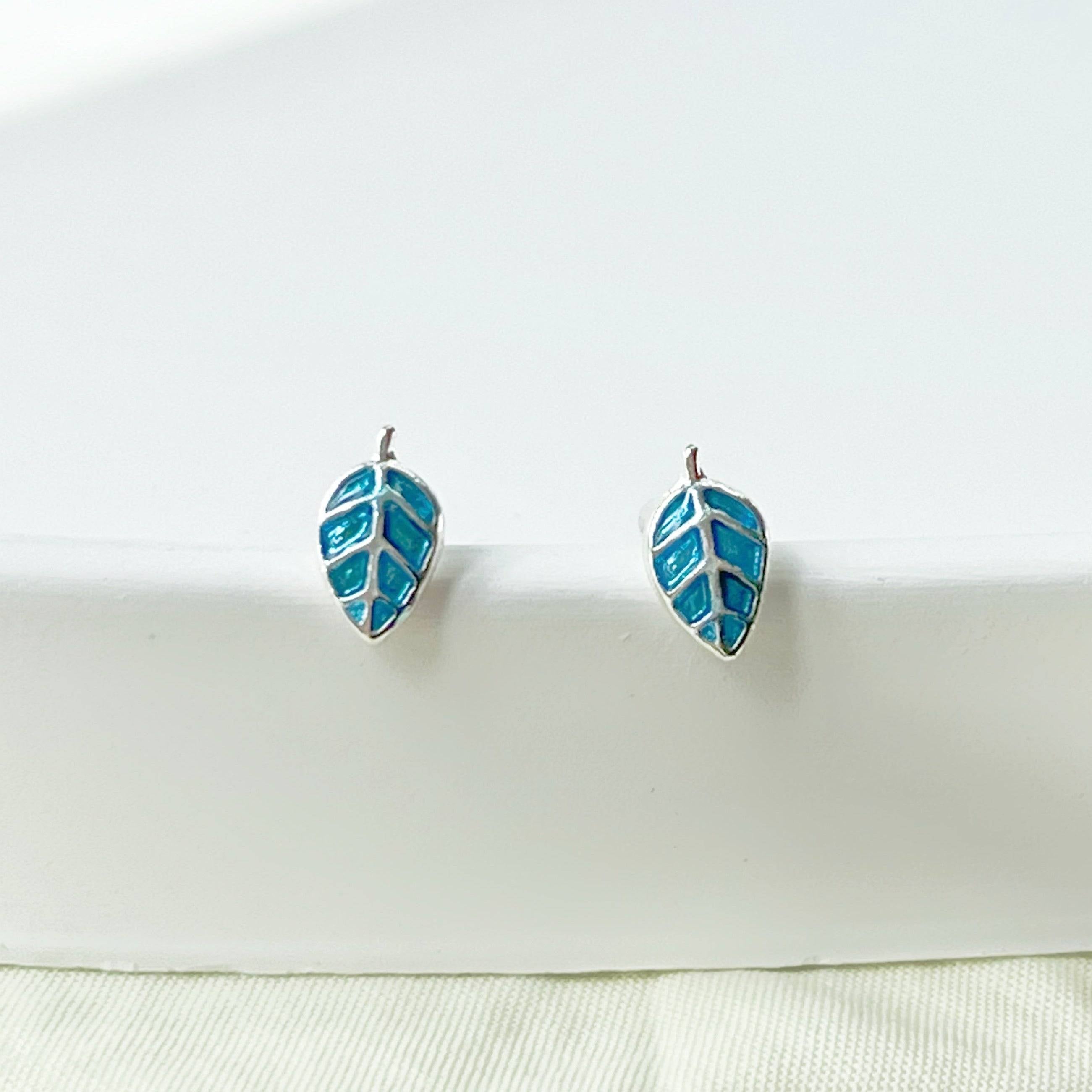 A pair of elegant blue leaves silver stud earrings, featuring a delicate design with sterling silver studs and a silver-plated bronze base.