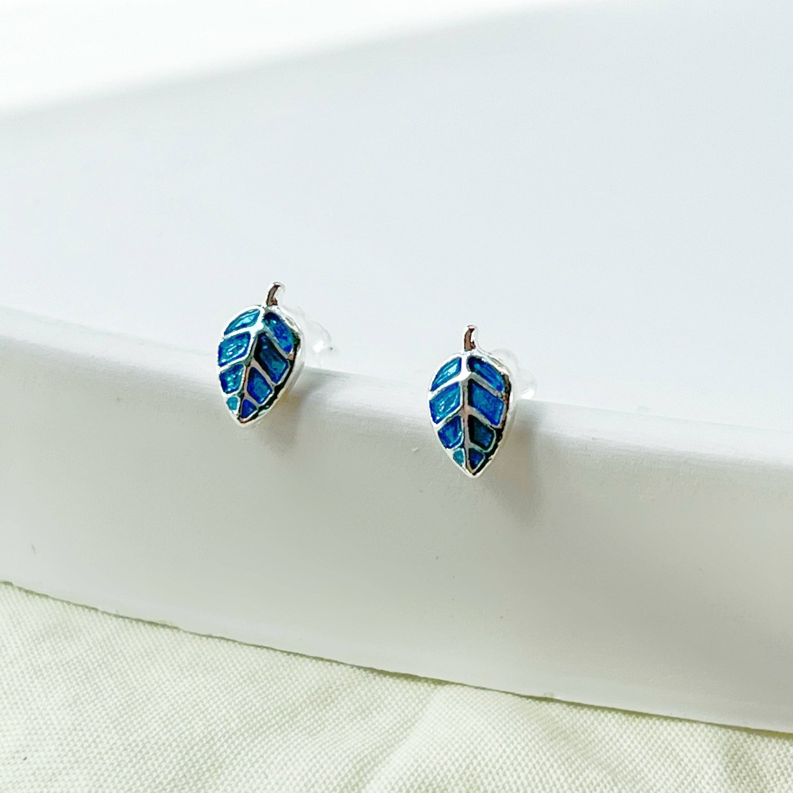 A pair of elegant blue leaves silver stud earrings, featuring a delicate design with sterling silver studs and a silver-plated bronze base.