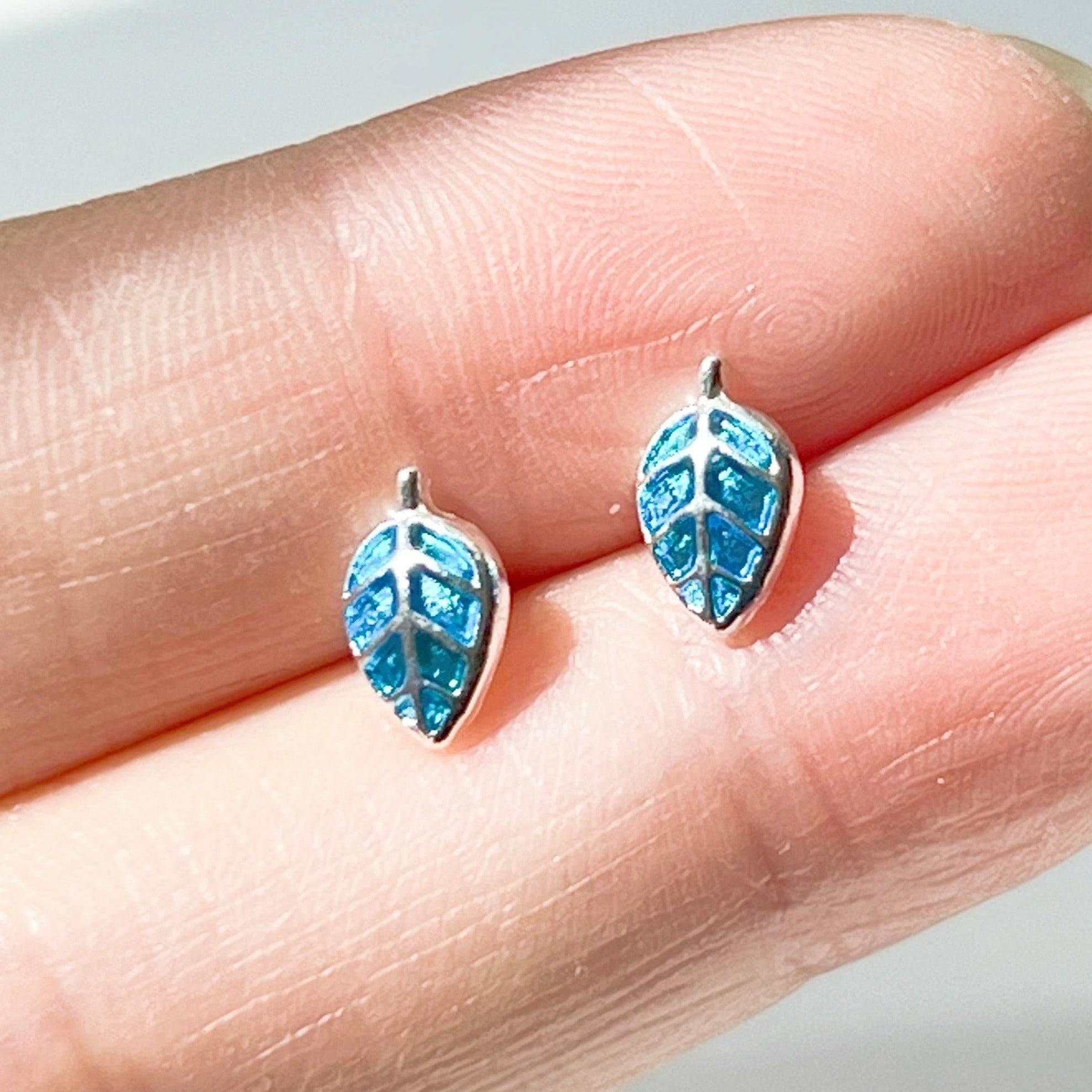 A pair of elegant blue leaves silver stud earrings, featuring a delicate design with sterling silver studs and a silver-plated bronze base.