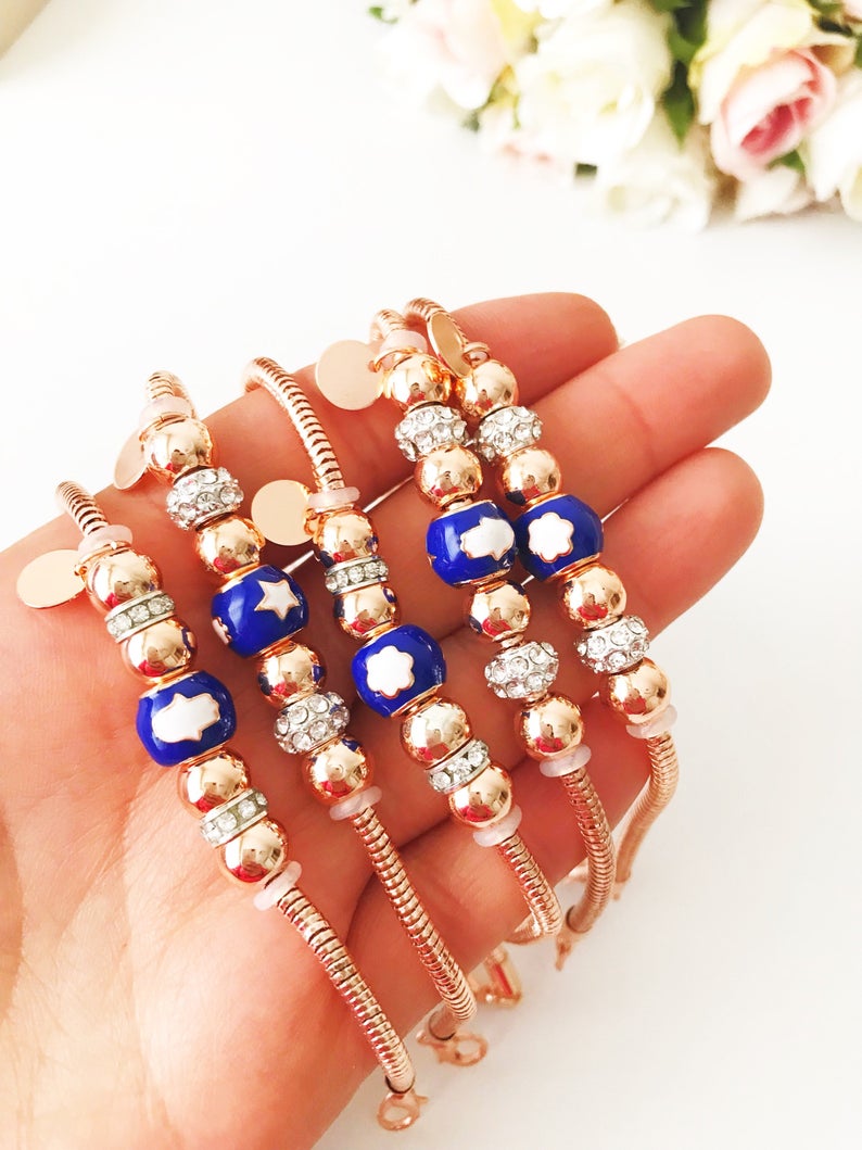 Blue Pandora Charm Bracelet featuring a rose gold chain and various charms including hamsa, four-leaf clover, and star figures.