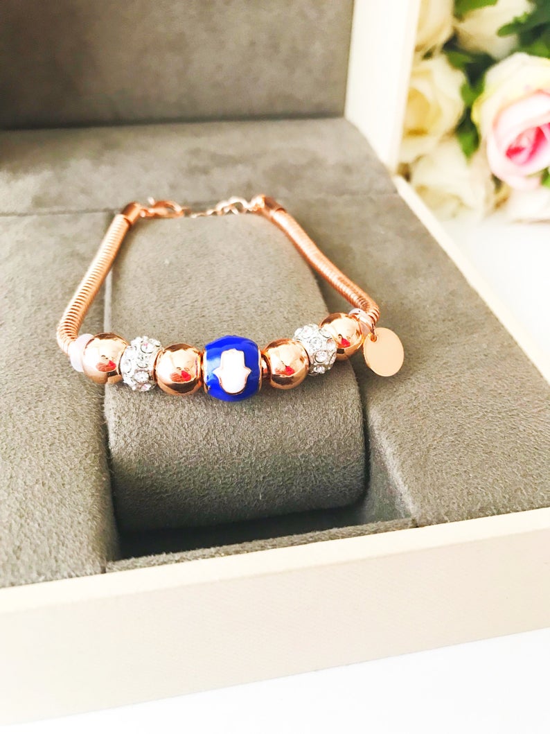 Blue Pandora Charm Bracelet featuring a rose gold chain and various charms including hamsa, four-leaf clover, and star figures.