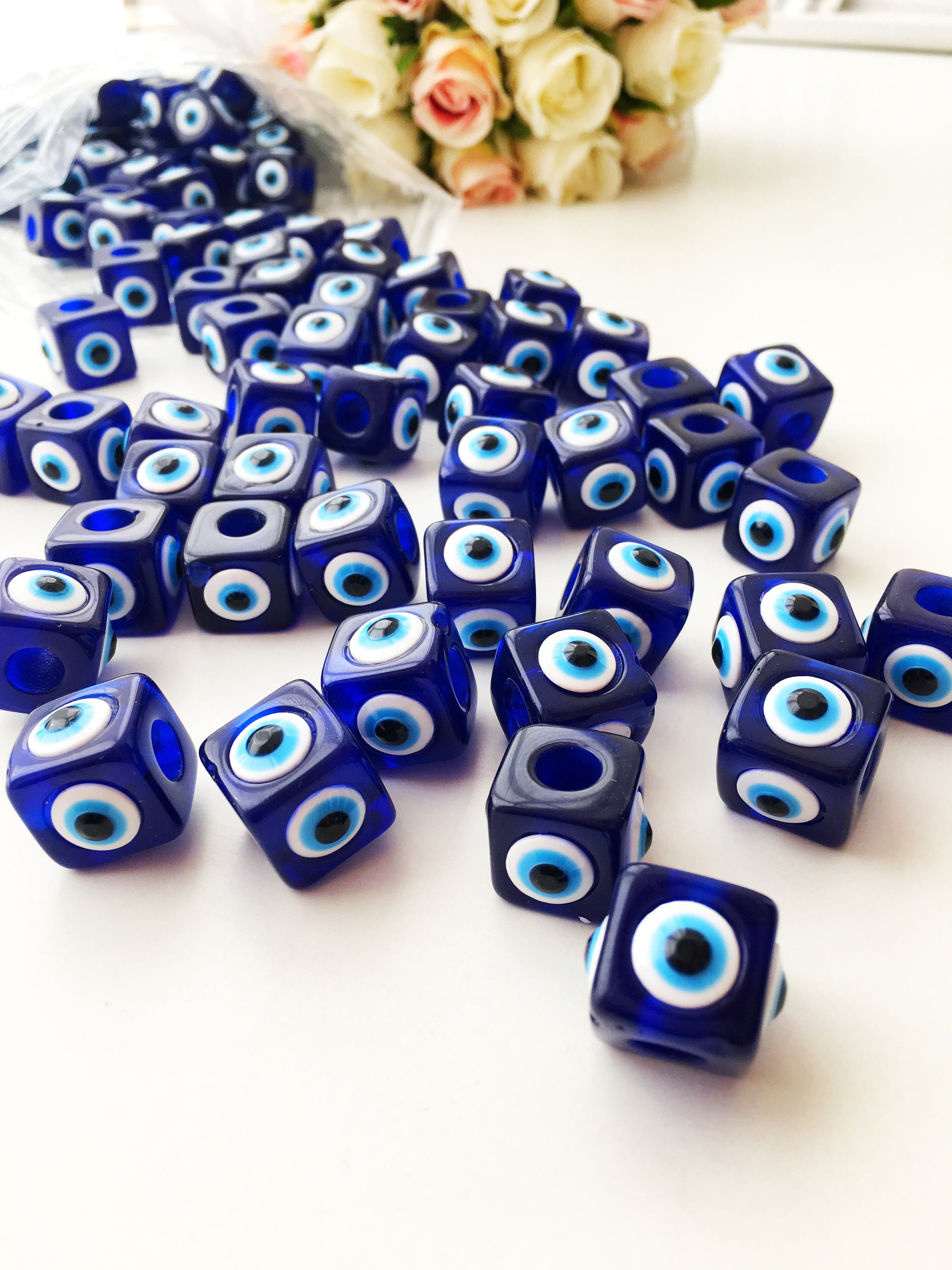 A collection of blue square evil eye beads featuring a protective charm design, ideal for jewelry making.