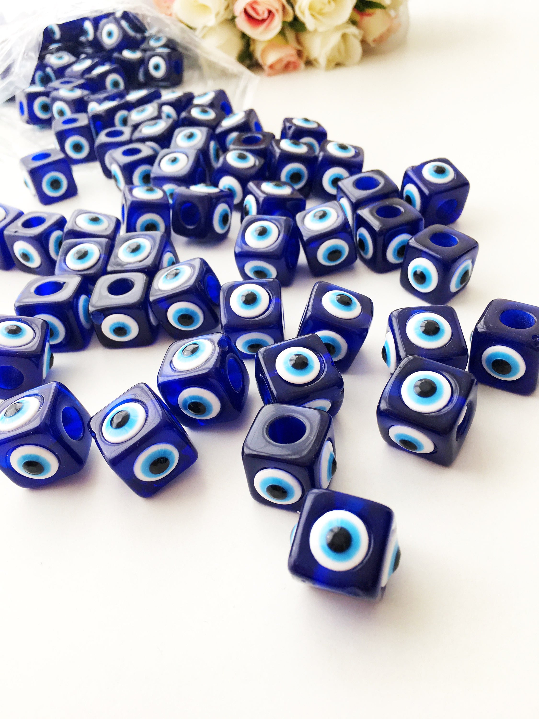 A collection of blue square evil eye beads featuring a protective charm design, ideal for jewelry making.