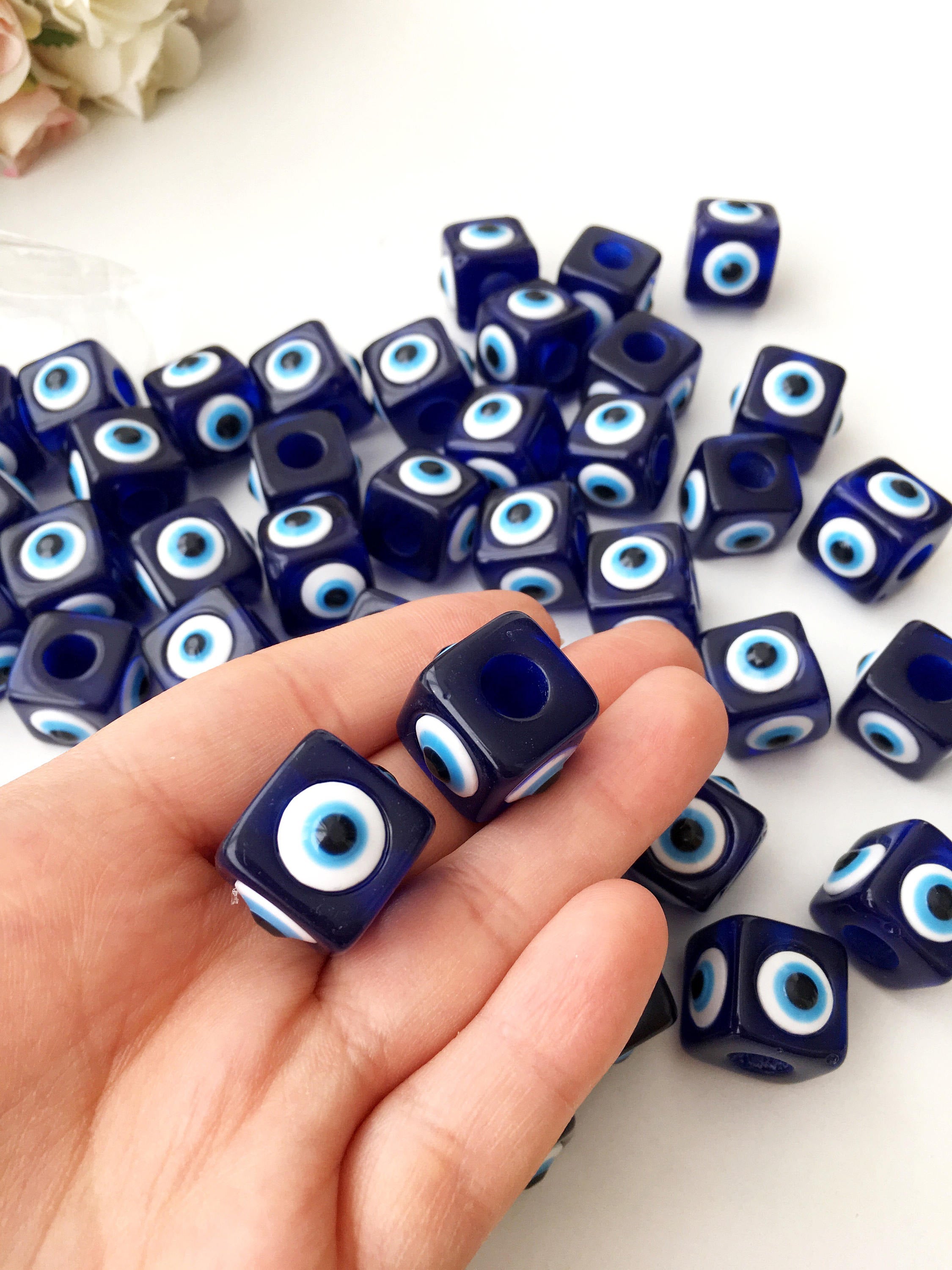 A collection of blue square evil eye beads featuring a protective charm design, ideal for jewelry making.