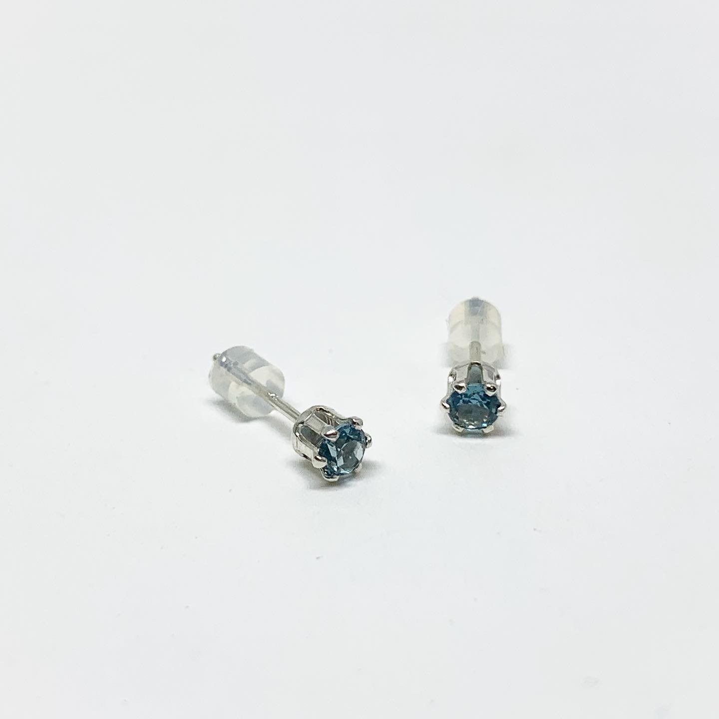 A pair of stunning blue zircon birthstone earrings featuring 3mm round faceted gemstones set in a 6 prong stud design, available in sterling silver or yellow gold fill.