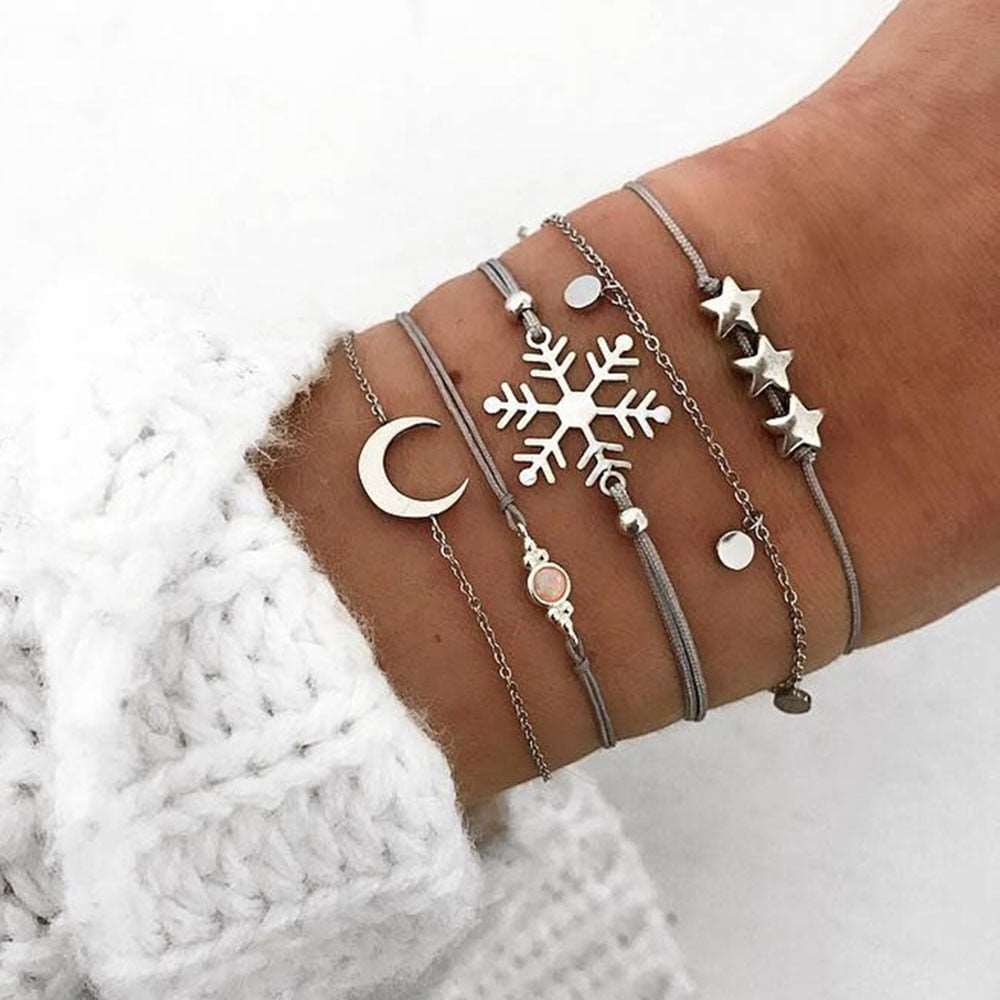 A stunning 5-piece bracelet set featuring star, moon, and snowflake designs in silver color, made from high-quality zinc alloy.