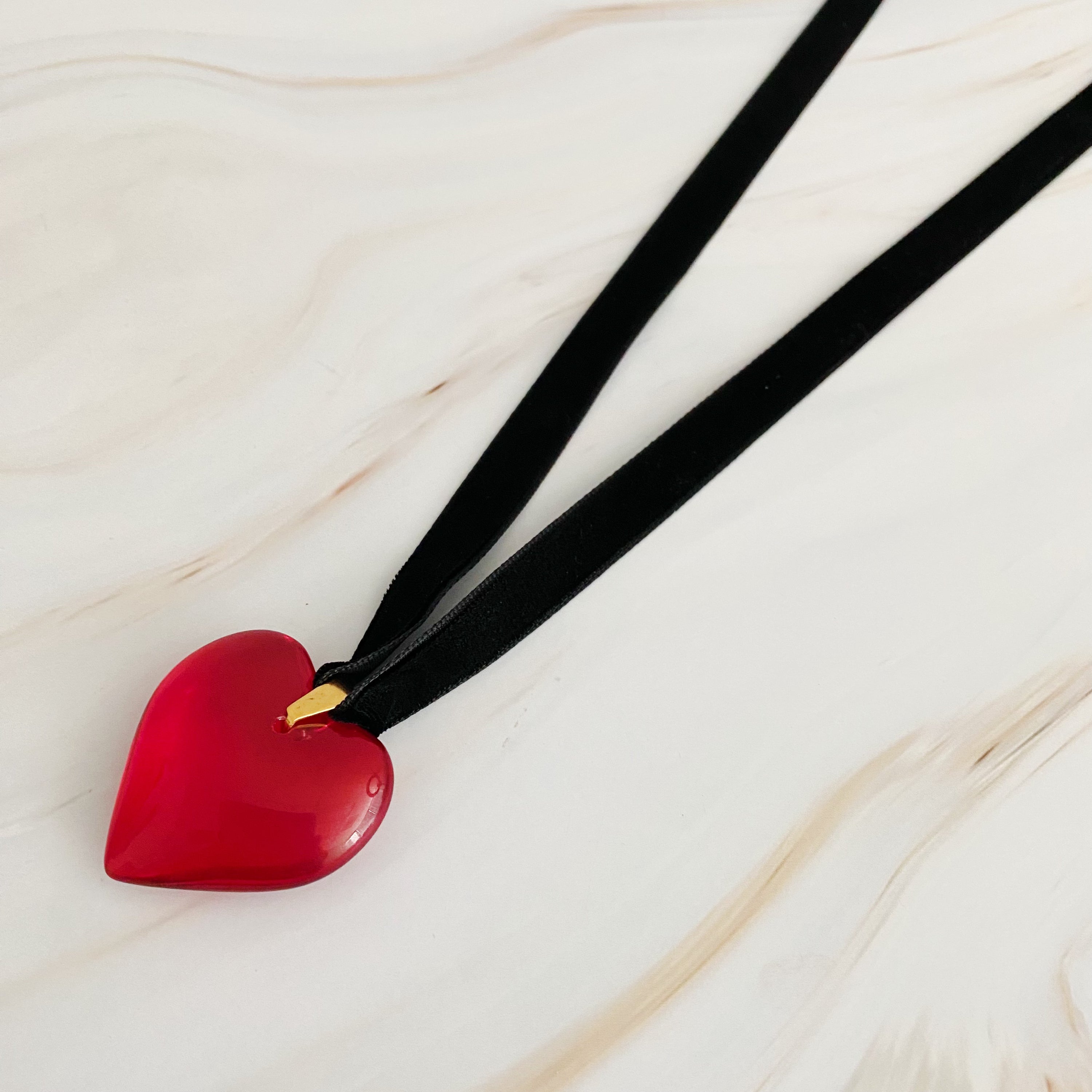 Bold In Red Black Sash Necklace featuring a red heart pendant and a black velvet sash, elegantly displayed on a neutral background.