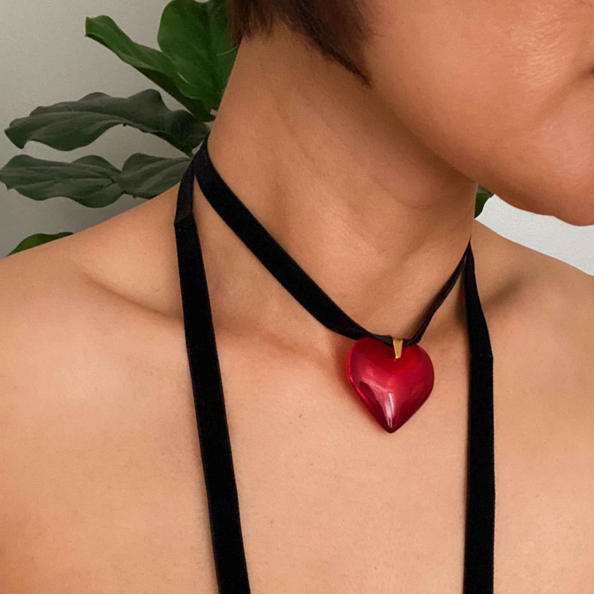 Bold In Red Black Sash Necklace featuring a red heart pendant and a black velvet sash, elegantly displayed on a neutral background.