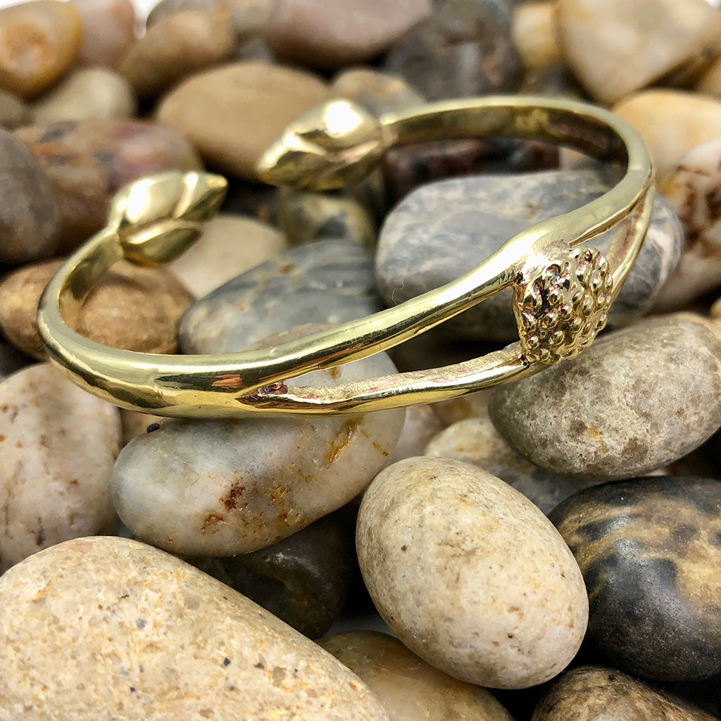 Gold bracelet on smooth pebbles.