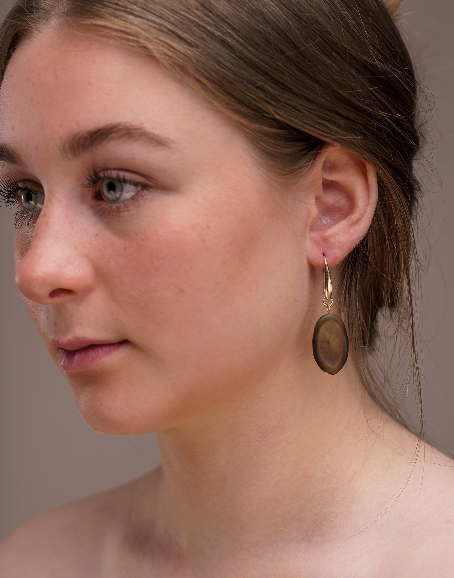 A pair of elegant Botanic Earrings made from Guapuruvu seeds with raw brass hoops, showcasing unique natural variations.