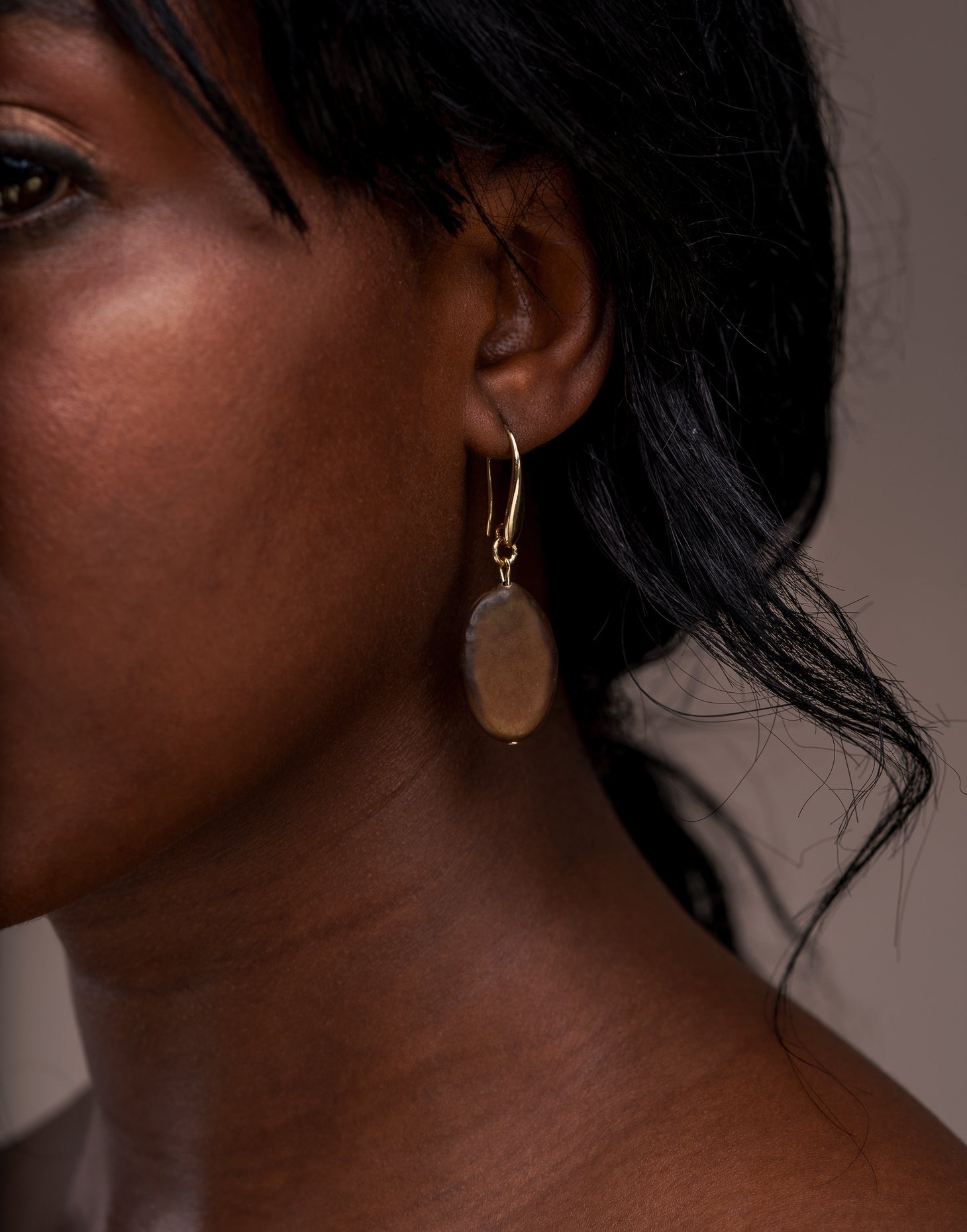 A pair of elegant Botanic Earrings made from Guapuruvu seeds with raw brass hoops, showcasing unique natural variations.