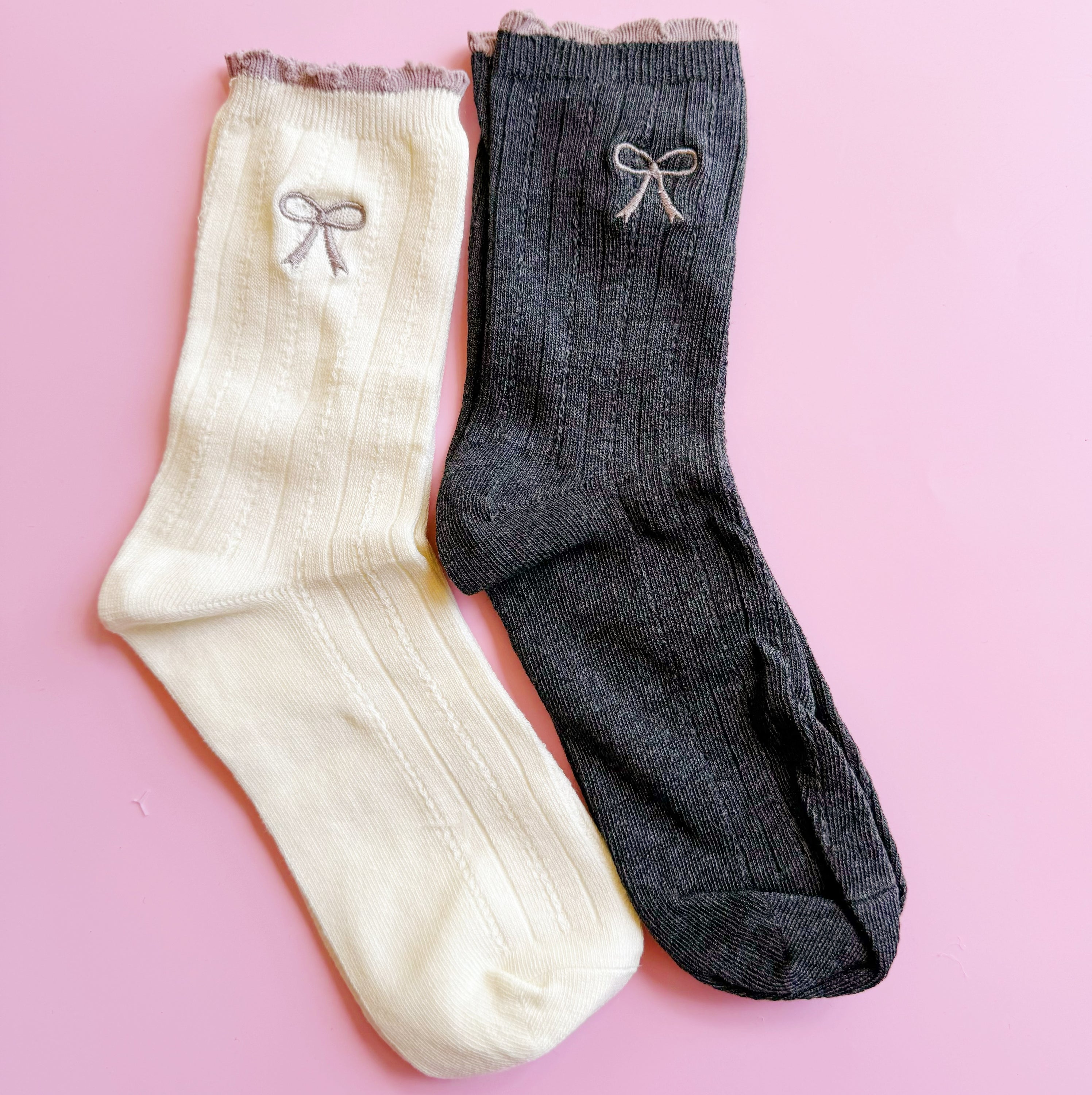 A set of two cute socks featuring embroidered bows, showcasing their soft fabric and stylish design.