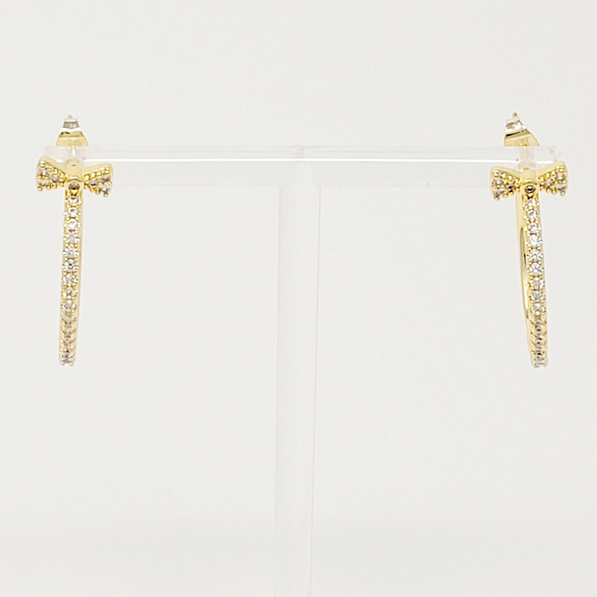 Elegant Bow On Top Hoop Earrings with shiny cubic zirconia, 18K gold plated brass, showcasing a chic design.