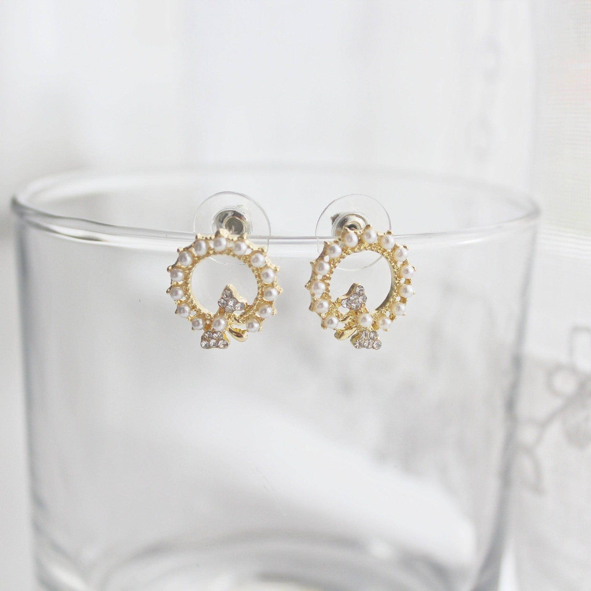 Elegant Bow Tie Pearl Circle Earrings featuring sterling silver studs, gold-plated bronze body, and sparkling artificial crystals and pearls.