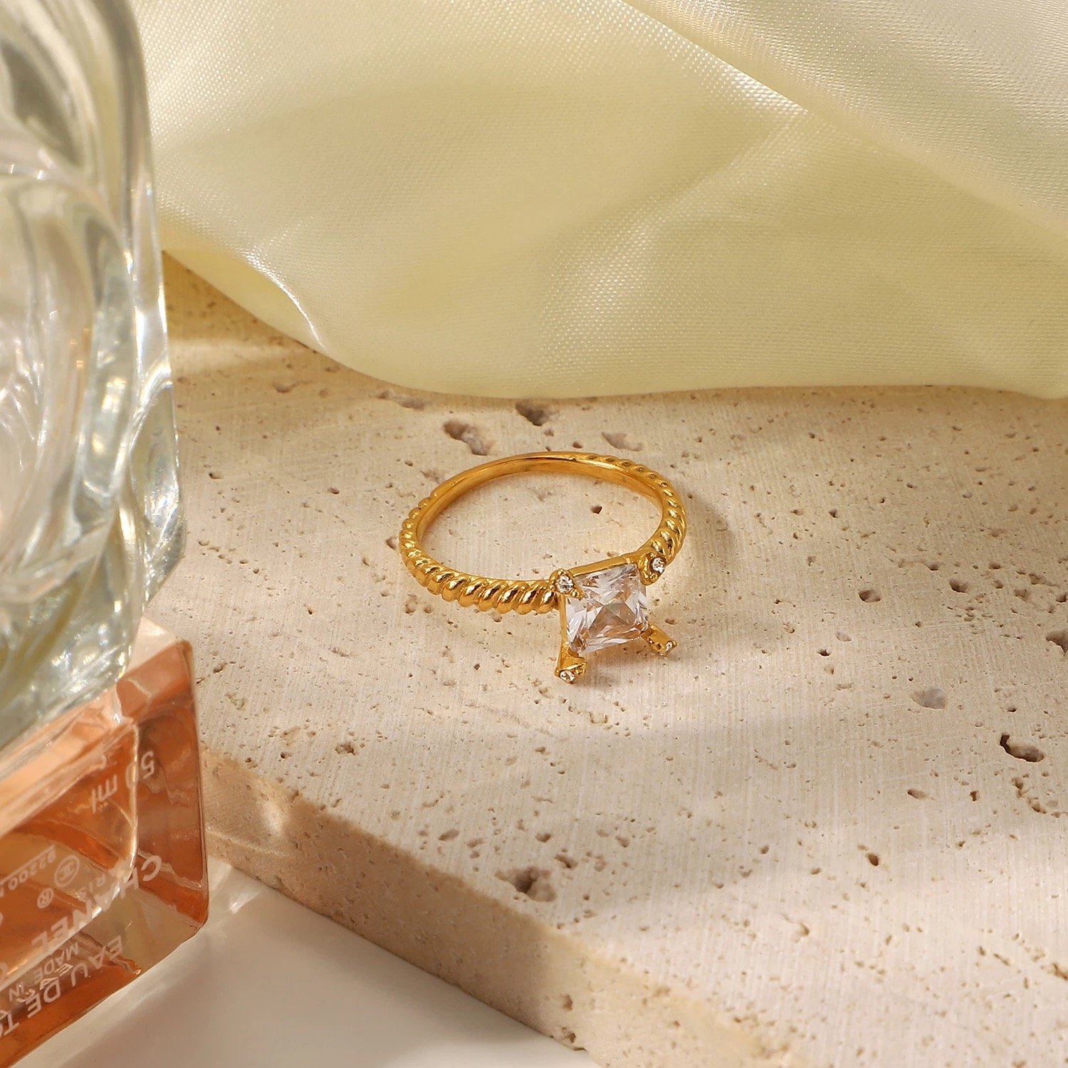 A beautiful adjustable braided single stone ring with a brushed gold finish, showcasing intricate design and elegance.