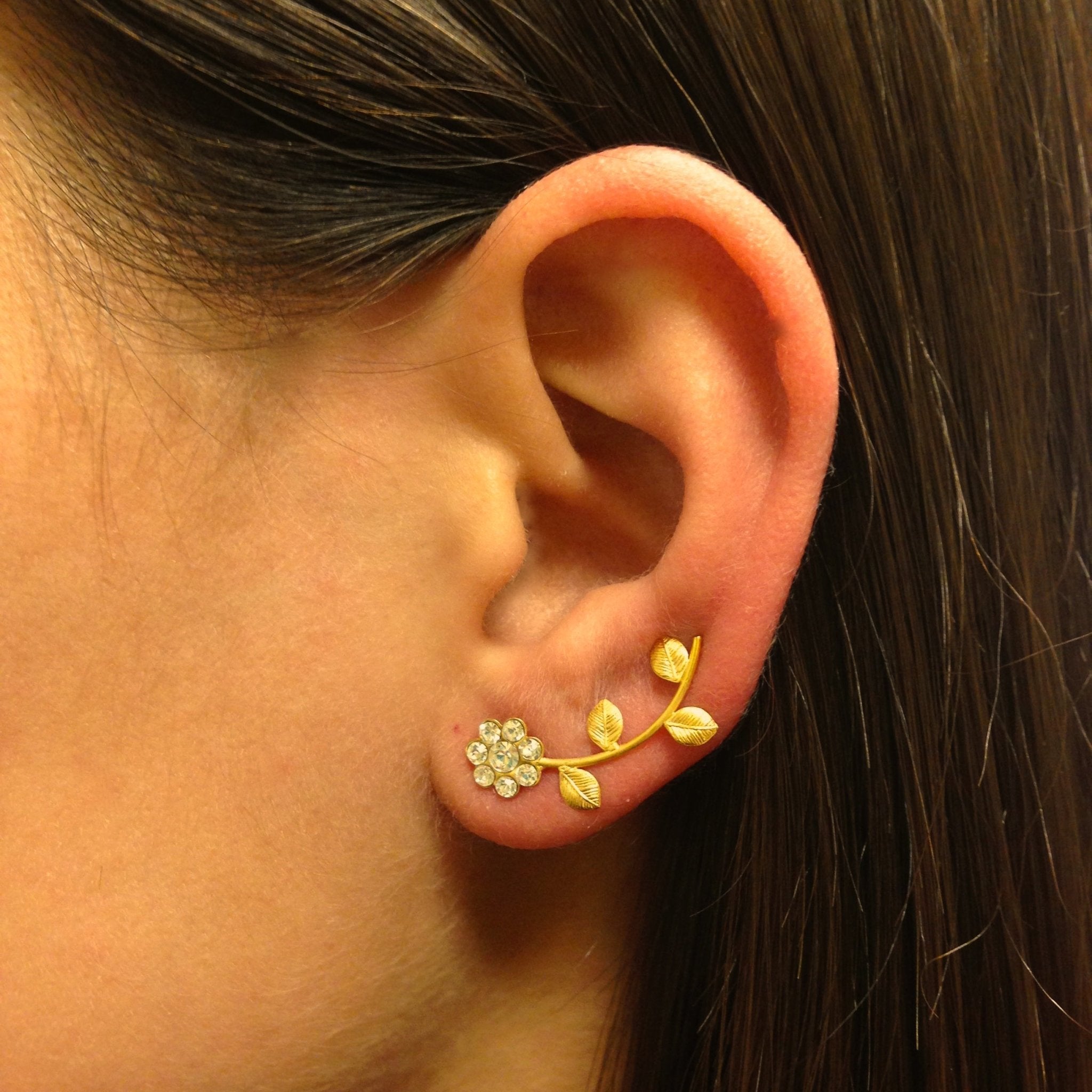 Handmade brass daisy ear cuffs and climbers earrings in gold with white CZ crystals, showcasing a floral design.