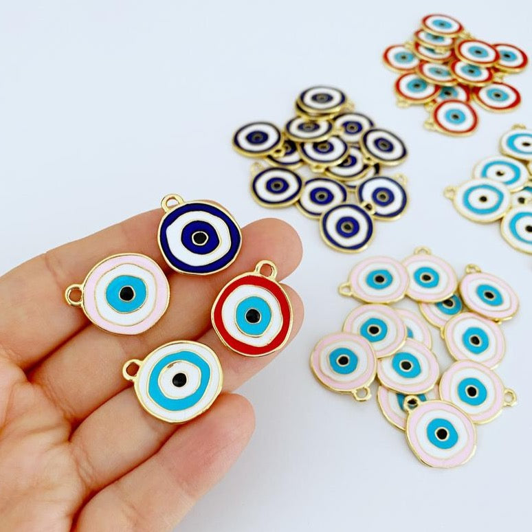 A detailed view of a brass evil eye charm featuring a vibrant blue design, perfect for DIY jewelry projects.