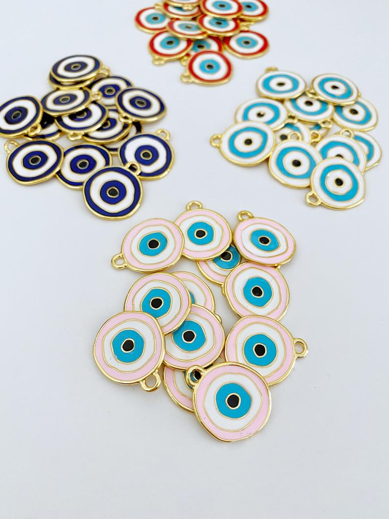 A detailed view of a brass evil eye charm featuring a vibrant blue design, perfect for DIY jewelry projects.