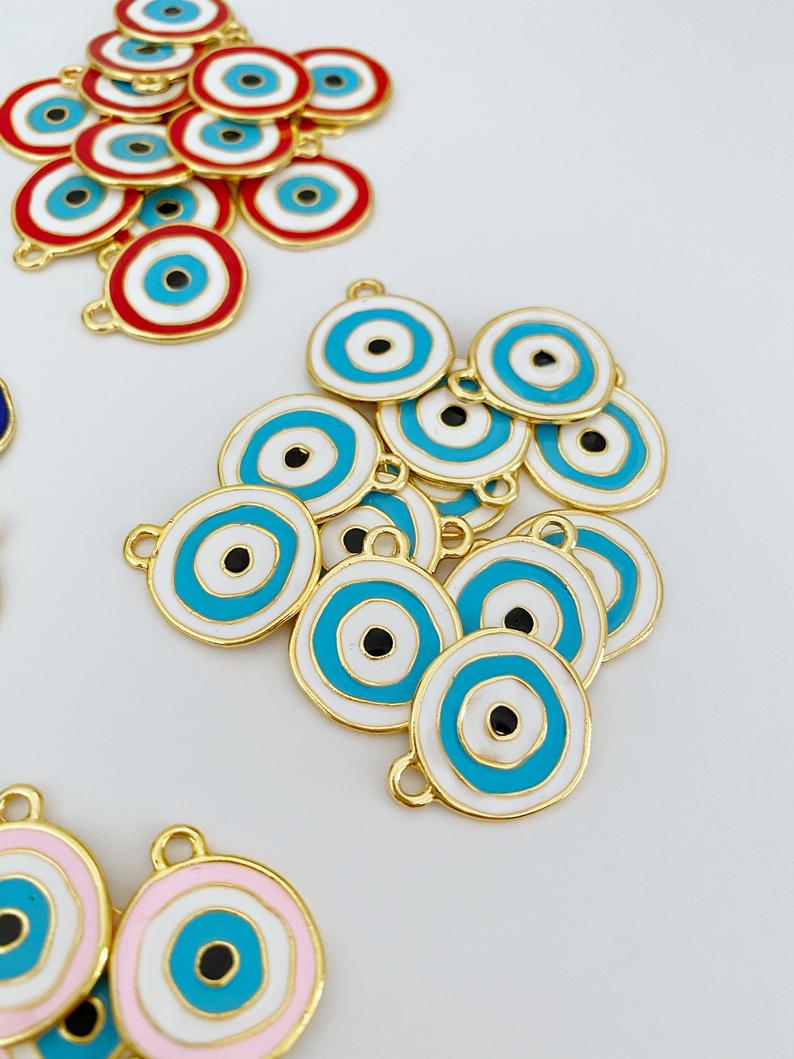 A detailed view of a brass evil eye charm featuring a vibrant blue design, perfect for DIY jewelry projects.