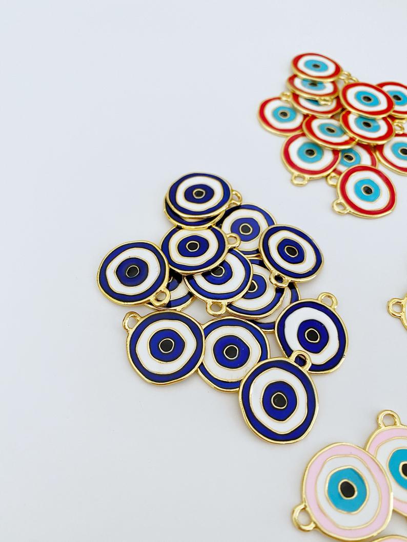 A detailed view of a brass evil eye charm featuring a vibrant blue design, perfect for DIY jewelry projects.