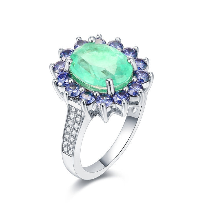 A beautiful Brazilian created blue tourmaline Paraiba halo ring set in 925 sterling silver with a white gold finish, showcasing a vibrant blue stone.